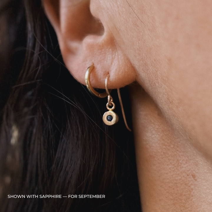 Close up of a person wearing bronze sapphire earrings | MIMOSA Handcrafted