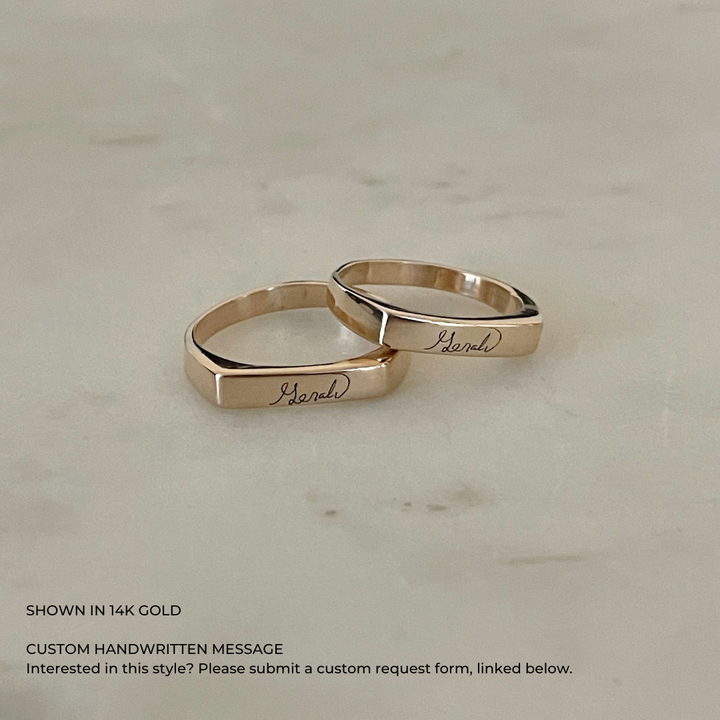 A custom engraved signet ring in a 14K gold, featuring a custom handwritten message.