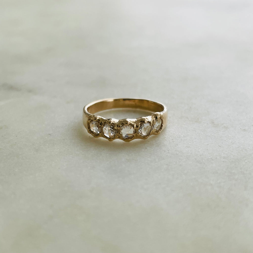 Five 3-millimeter rose cut diamonds set in a simple and delicate 14k gold ring