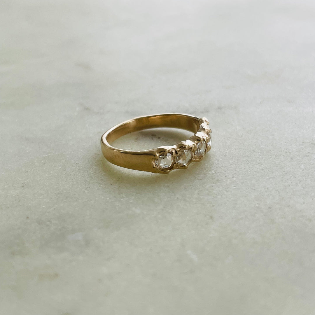 Five 3-millimeter rose cut diamonds set in a simple and delicate 14k gold ring