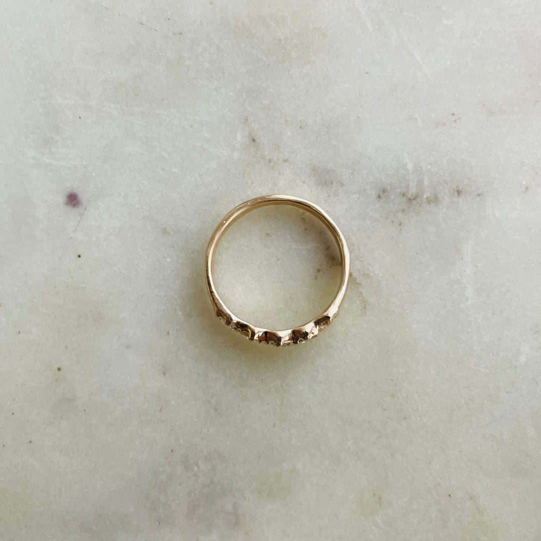 Five 3-millimeter rose cut diamonds set in a simple and delicate 14k gold ring