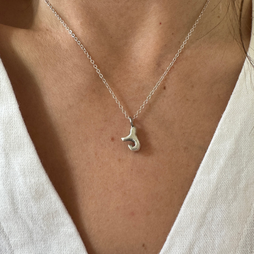 Woman Wears MIMOSA Handcrafted Heart Hand Necklace in Sterling Silver