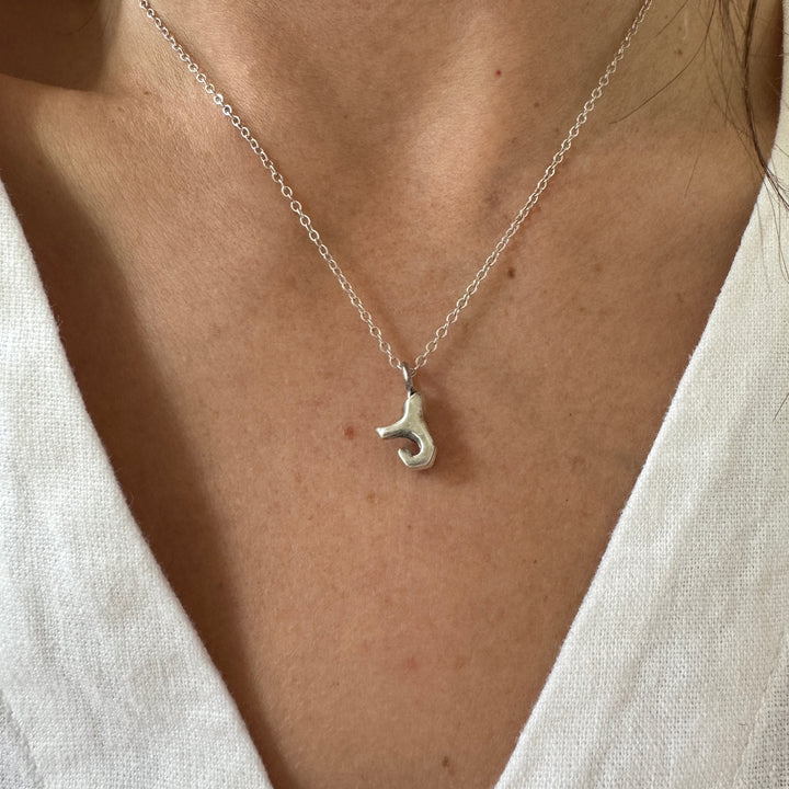 Woman Wears MIMOSA Handcrafted Heart Hand Necklace in Sterling Silver