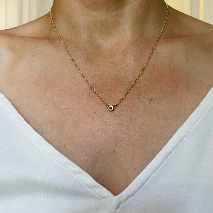 Woman Wearing Handmade Bronze Grace Pendant Necklace With Sapphire Birthstone