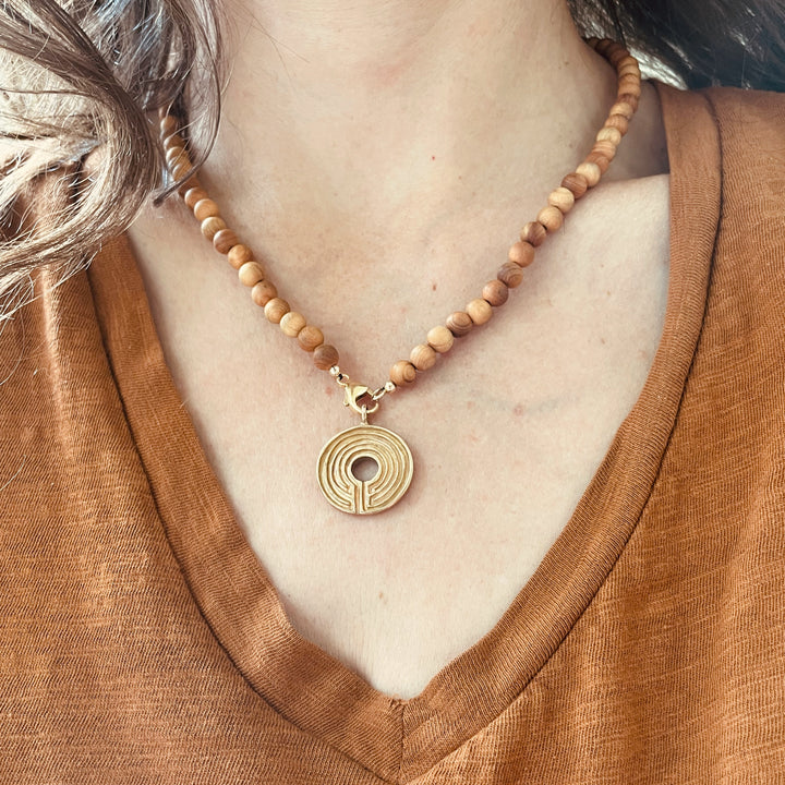 Woman Wearing Sandalwood Beaded Necklace With Optional Bronze Labyrinth Pendant