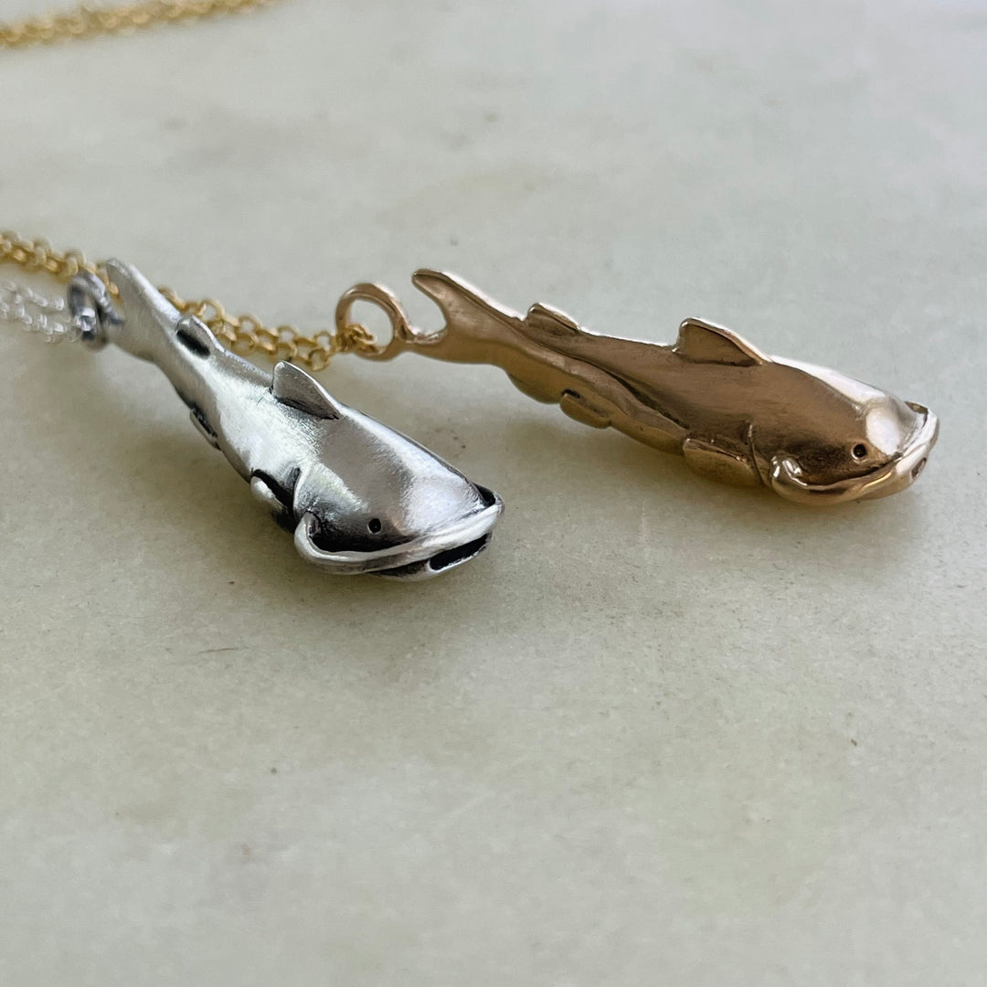 Bronze And Sterling Catfish Pendants Side By Side