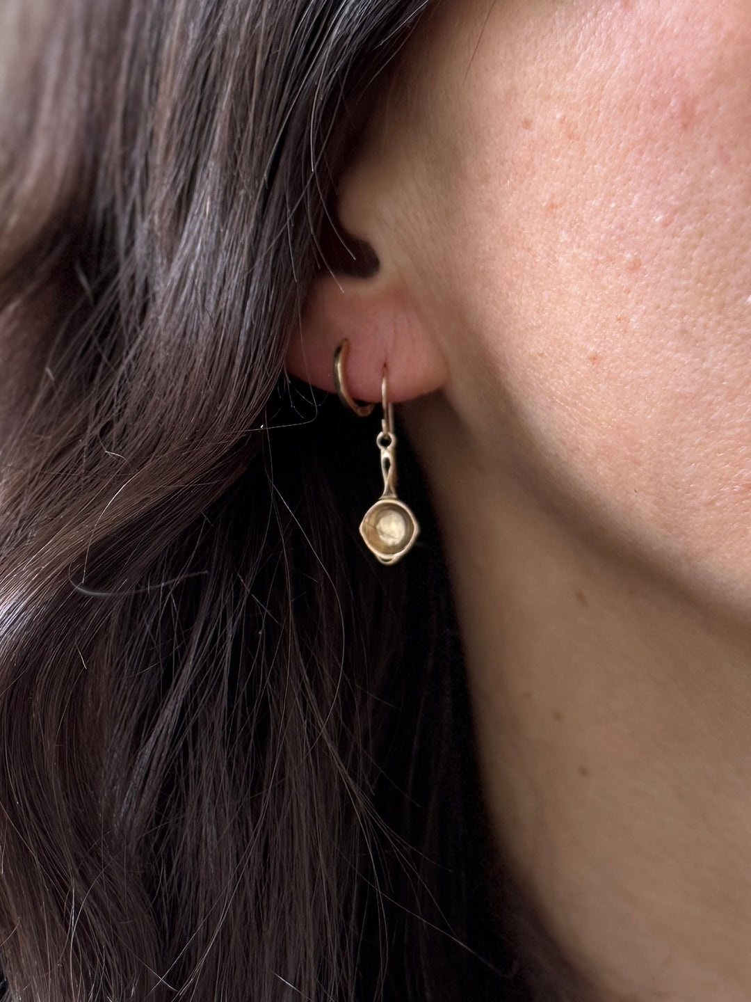 Close Up of a Person Wearing Bronze Skillet Shaped Earrings | MIMOSA Handcrafted