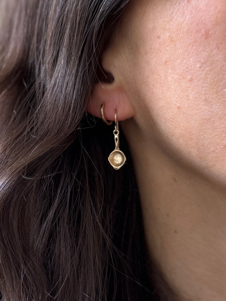 Close Up of a Person Wearing Bronze Skillet Shaped Earrings | MIMOSA Handcrafted