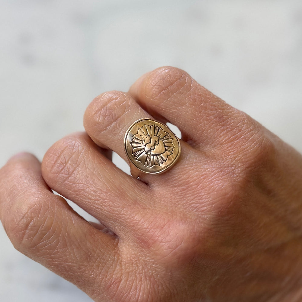 Person wears Bronze Sacred Heart Ring from MIMOSA Handcrafted