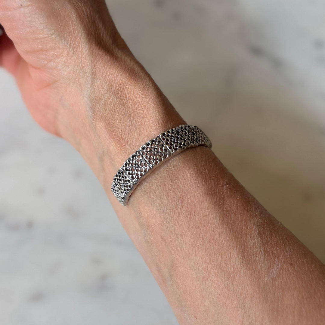 Person wears a handmade granny square bracelet in sterling silver by MIMOSA Handcrafted