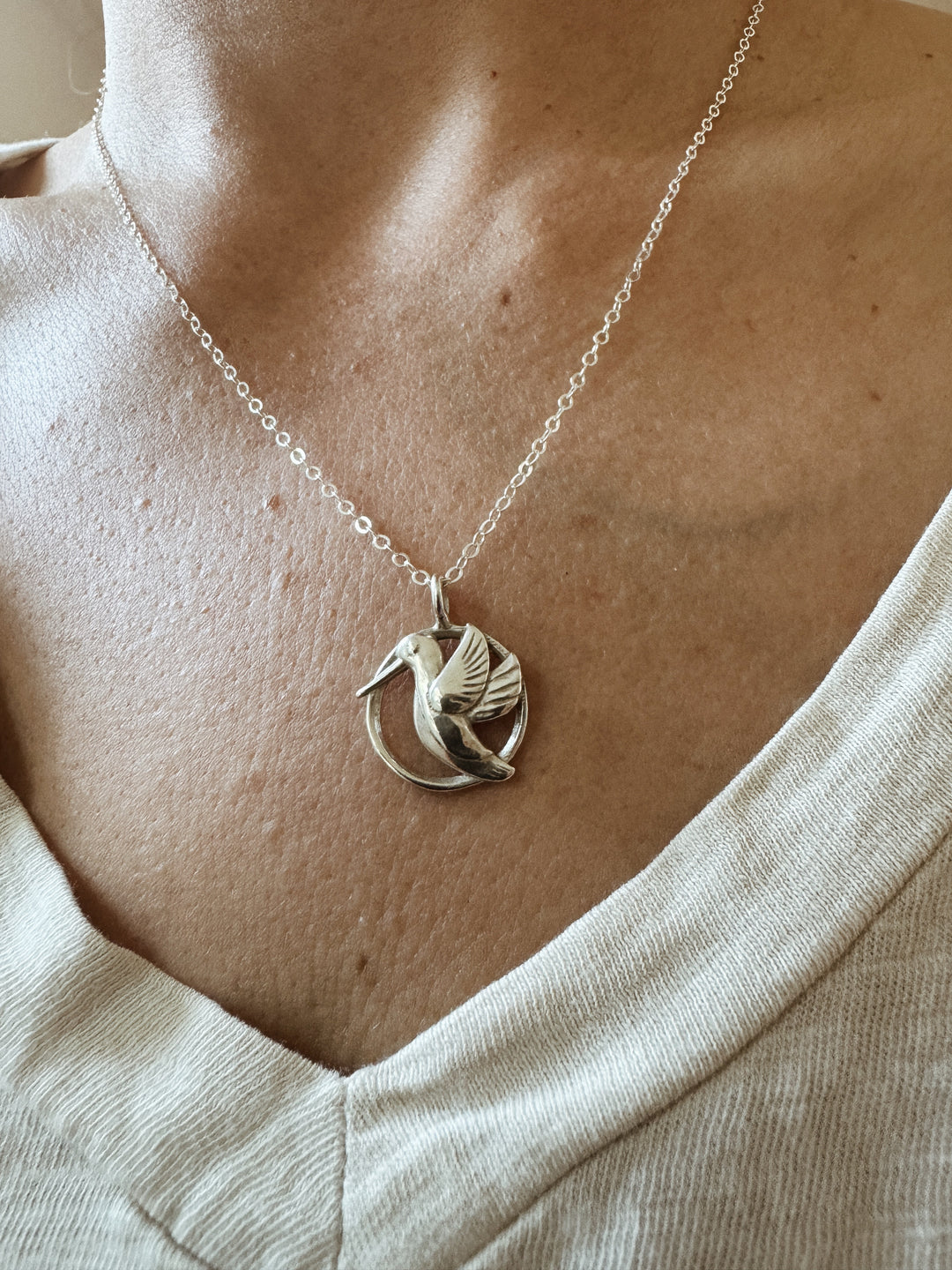 Woman Wears the MIMOSA Handcrafted Hummingbird Pendant in Sterling Silver