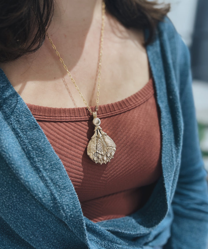 Woman Wears MIMOSA Handcrafted Bronze Loupe Necklace on Gold-Filled Inherited Chain