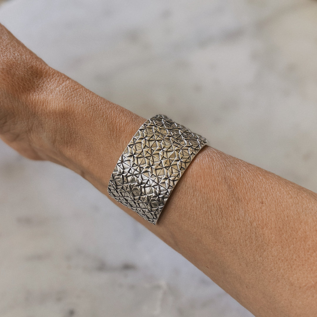 Person wears handmade 3-row quilt bracelet in sterling silver by MIMOSA Handcrafted