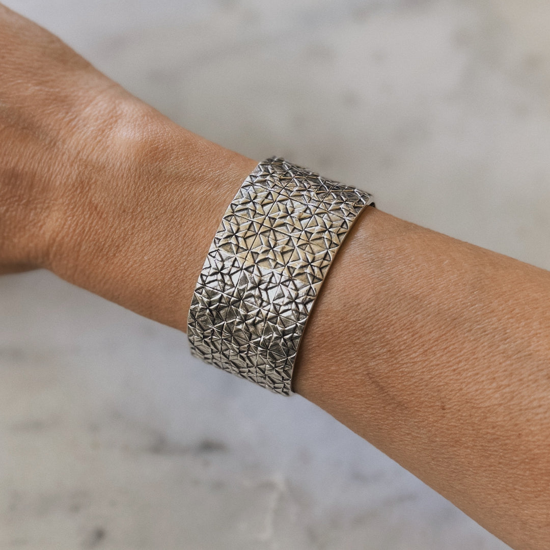 Person wears handmade 3-row quilt bracelet in sterling silver by MIMOSA Handcrafted