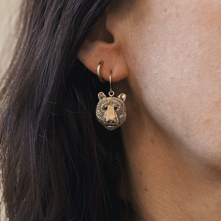 Close Up of a Person Wearing Bronze Bear Head Shaped Earrings