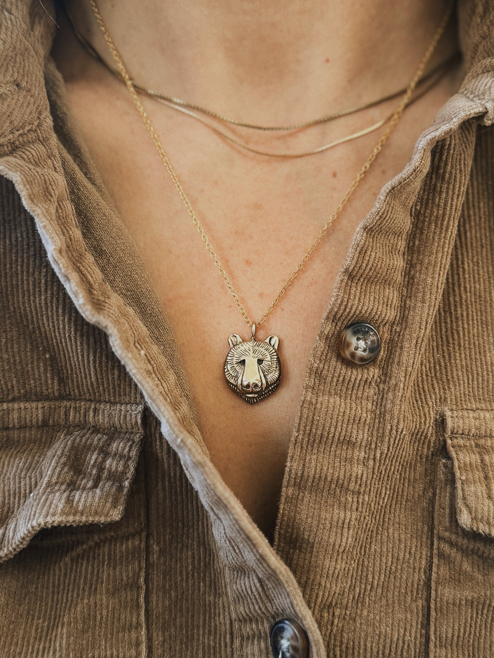 Close-Up of a Person wearing a Bronze Bear Head Pendant