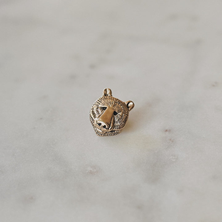Bronze Bear Head Pin on Marble Surface