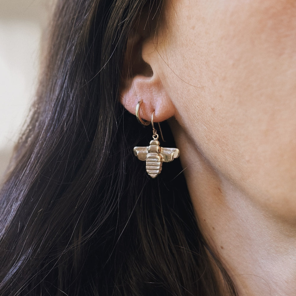 Person wears Bronze Bee Earrings from MIMOSA Handcrafted