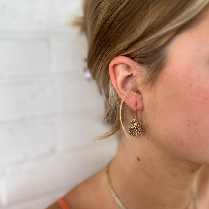 Woman Wears MIMOSA Handcrafted Camellia Earrings in Bronze.