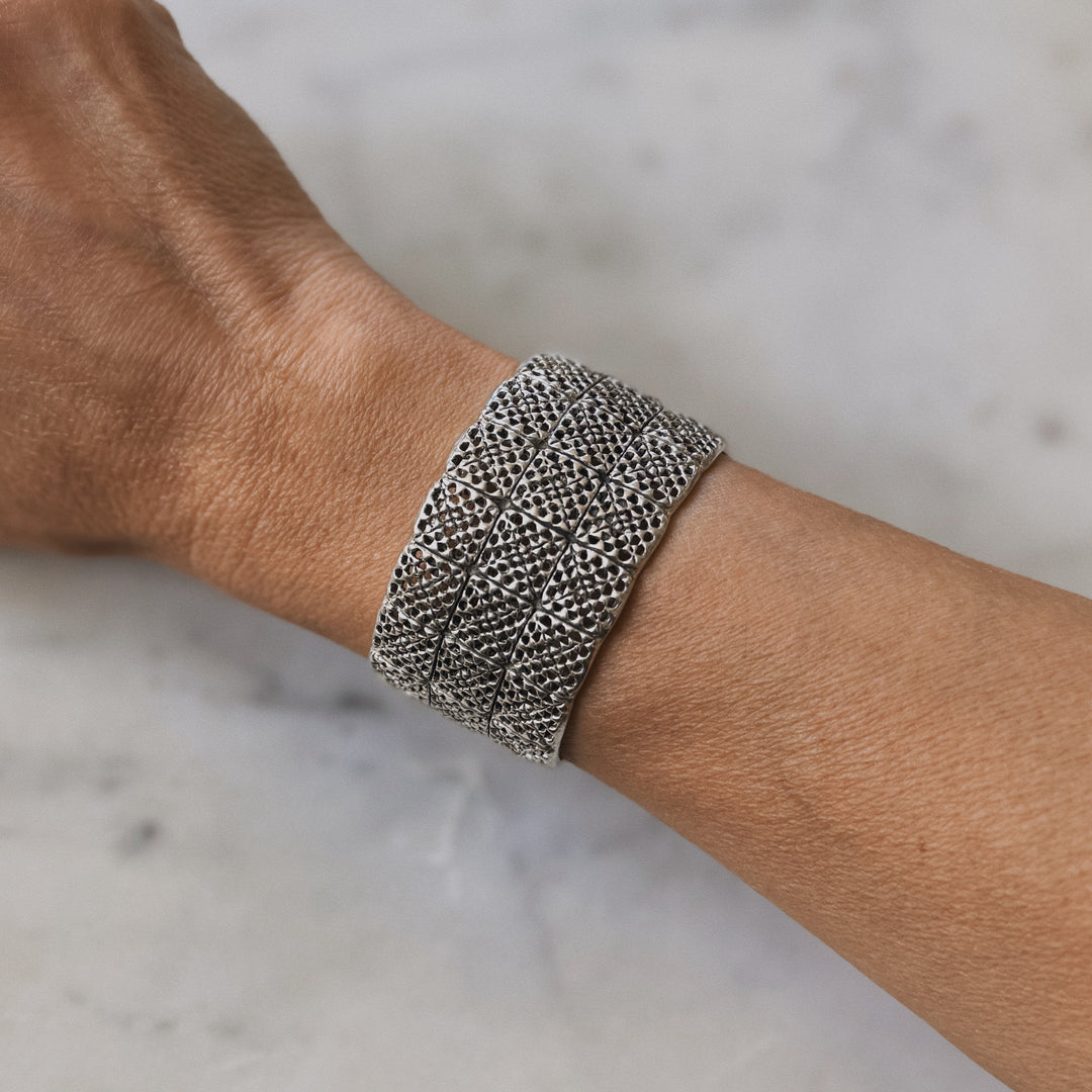 Person wears handmade 3-row granny square bracelet in sterling silver by MIMOSA Handcrafted