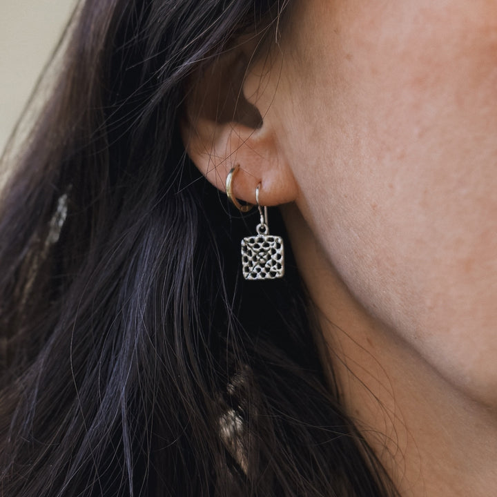 Person wears handmade granny square earrings in sterling silver by MIMOSA Handcrafted