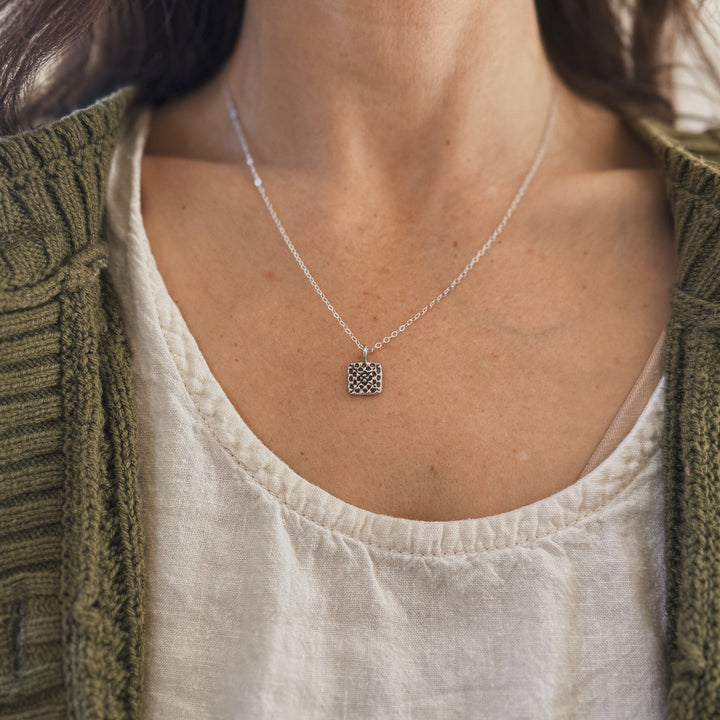 Person wears a handmade granny square necklace in silver by MIMOSA Handcrafted