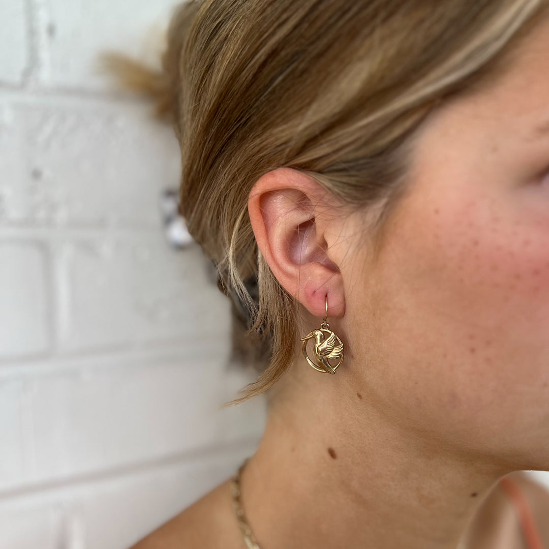 Woman Wears MIMOSA Handcrafted Hummingbird Earrings in Bronze.