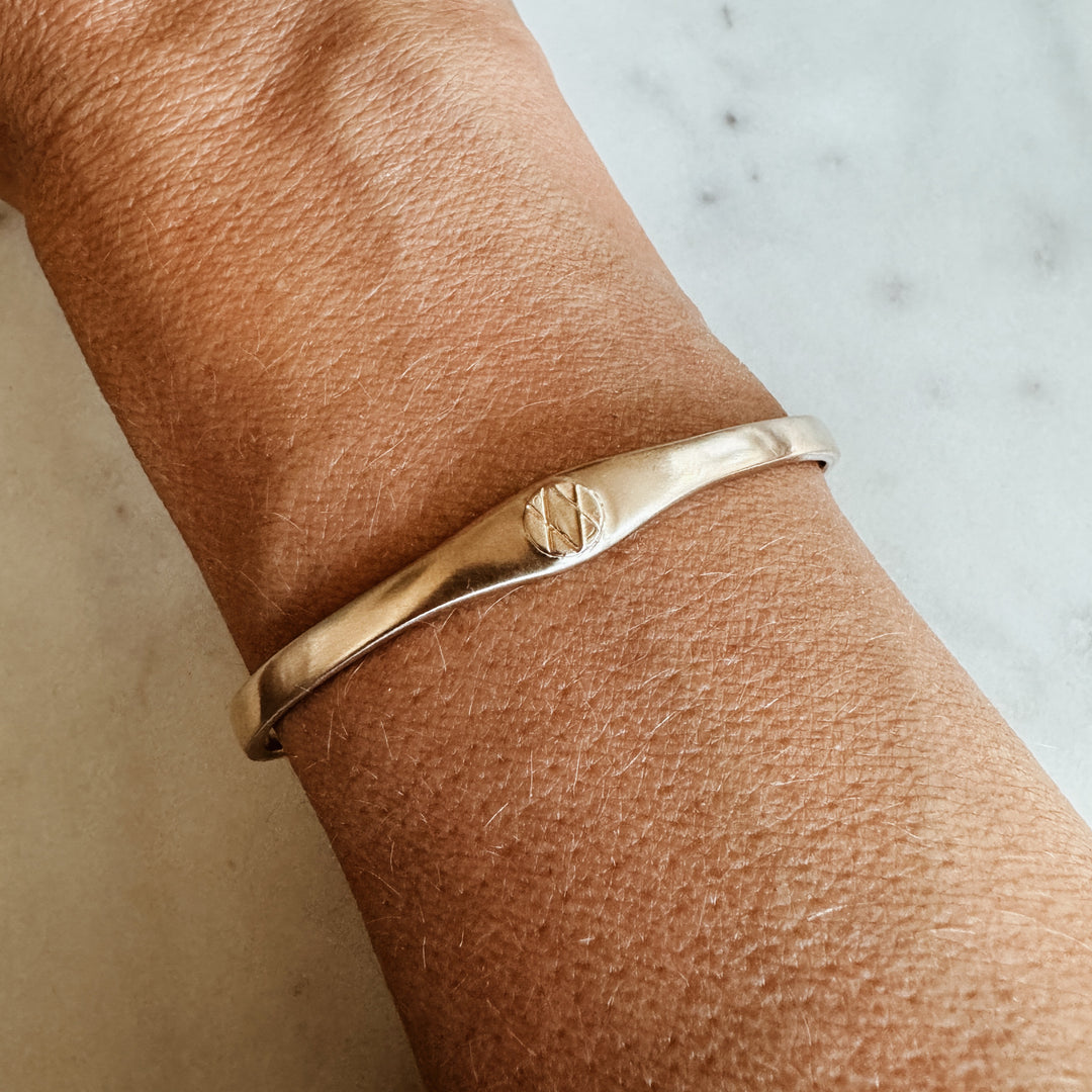 Woman Wears the MIMOSA Handcrafted Joy and Sorrow Cuff in Bronze