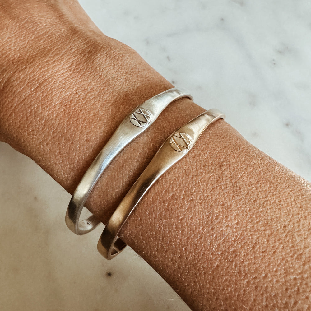 Woman Wears the MIMOSA Handcrafted Joy and Sorrow Cuff in Sterling Silver and Bronze