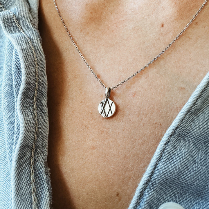 Woman Wears a MIMOSA Handcrafted Joy and Sorrow Pendant in Sterling Silver