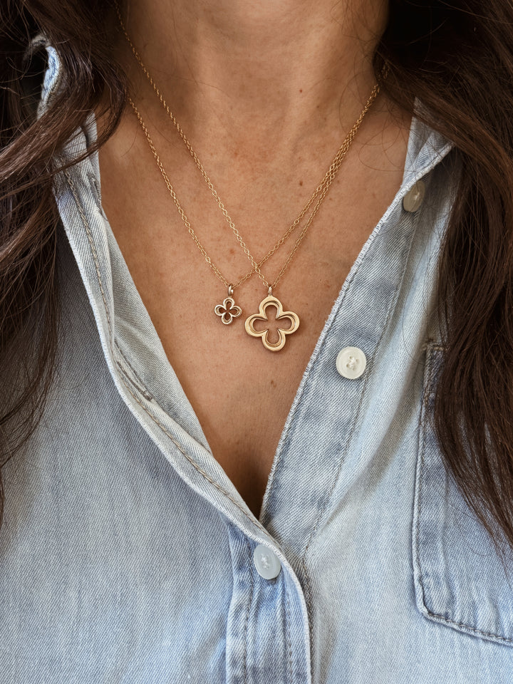 Woman Wears the MIMOSA Handcrafted Large and Small Quatrefoil Pendants in Bronze