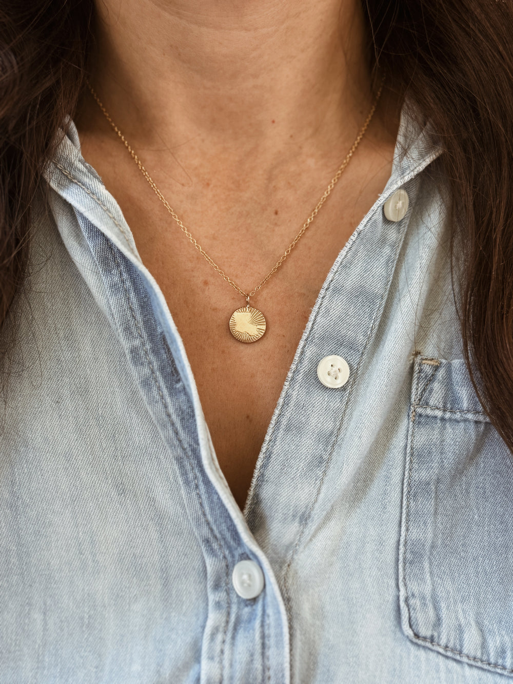 Woman Wears the MIMOSA Handcrafted Louisiana Burst Pendant in Bronze