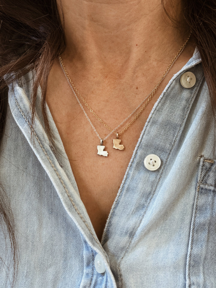 Woman Wears the MIMOSA Handcrafted Louisiana State Pendants in Bronze and Sterling Silver