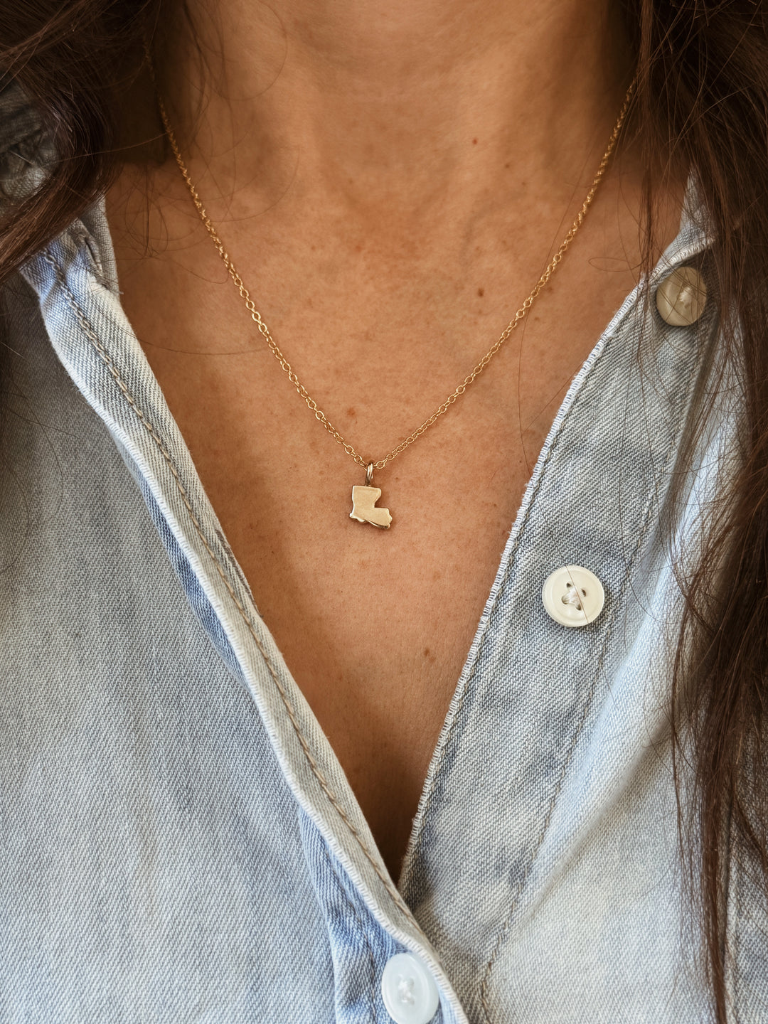 Woman Wears the MIMOSA Handcrafted Louisiana State Pendant in Bronze