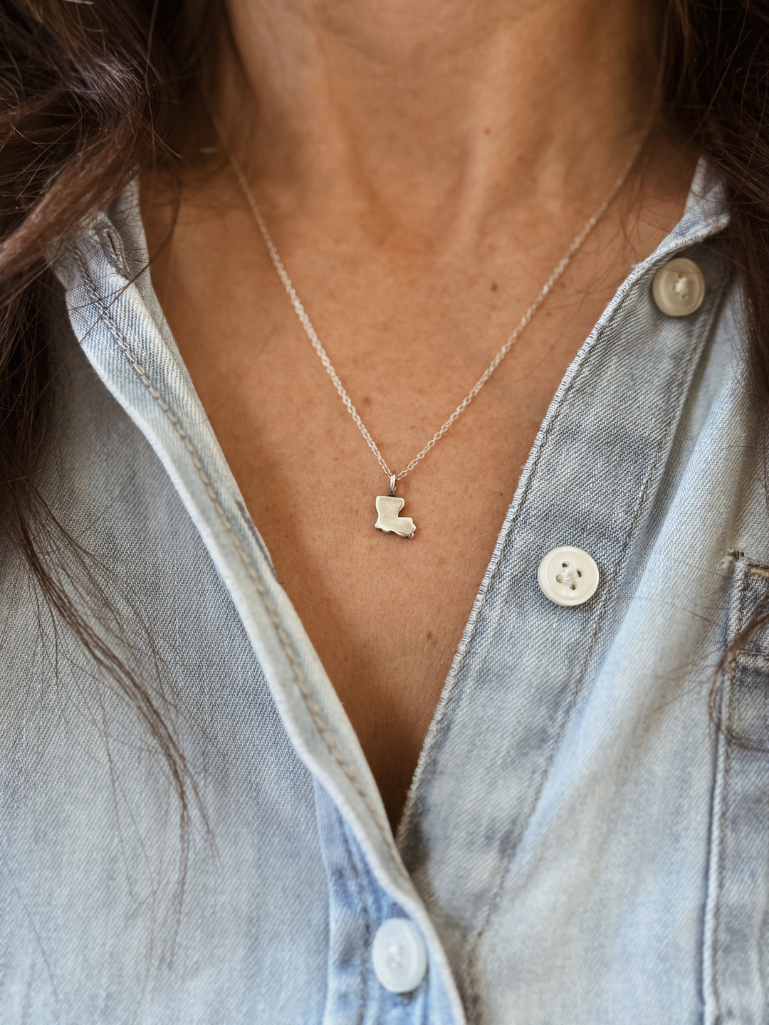 Woman Wears the MIMOSA Handcrafted Louisiana State Pendant in Sterling Silver