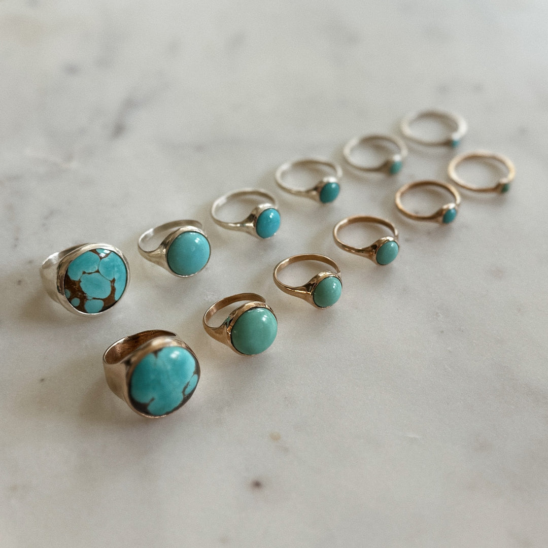 Handmade Bronze and Silver Turquoise Rings In Various Sizes on a Marble Surface | MIMOSA Handcrafted