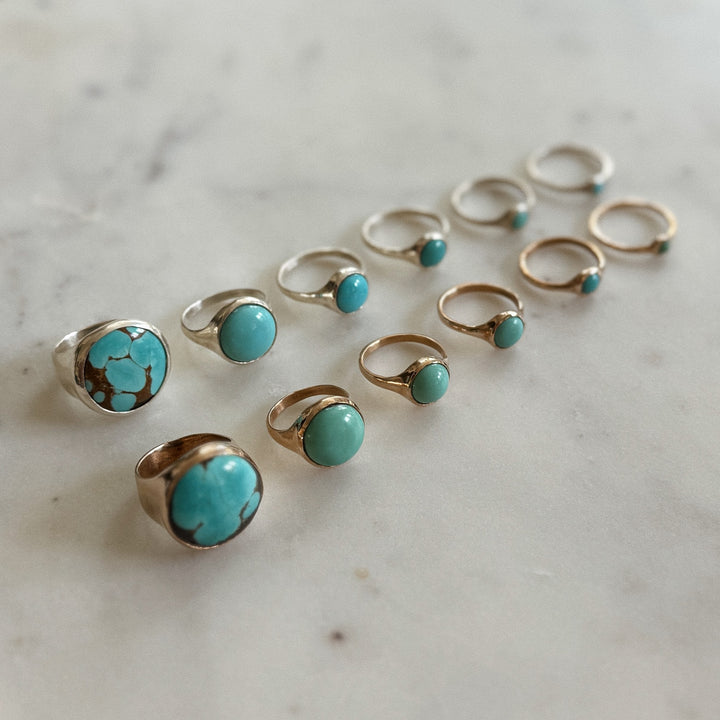 Handmade Bronze and Silver Turquoise Rings In Various Sizes on a Marble Surface | MIMOSA Handcrafted