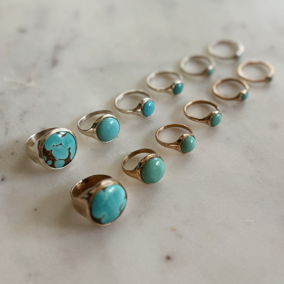 Handmade Bronze and Silver Turquoise Rings In Various Sizes on a Marble Surface | MIMOSA Handcrafted