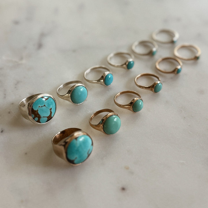 Handmade Bronze and Silver Turquoise Rings In Various Sizes on a Marble Surface | MIMOSA Handcrafted