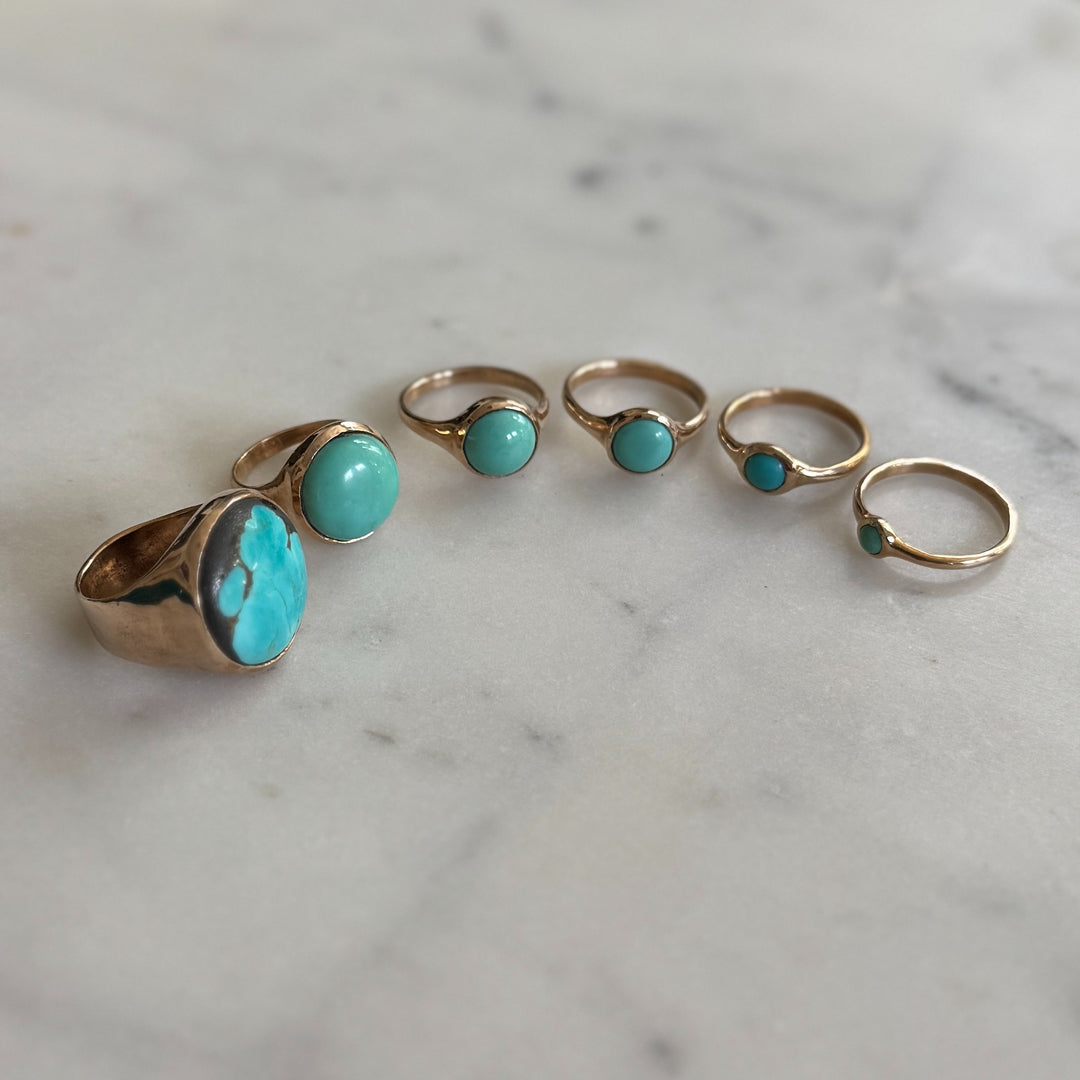 Handmade Bronze Turquoise Rings In Various Sizes on a Marble Surface | MIMOSA Handcrafted