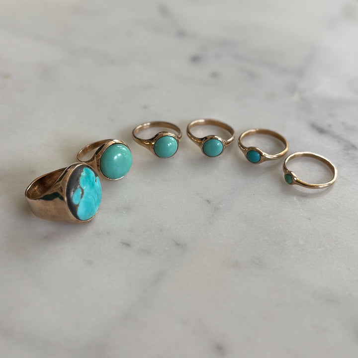 Handmade Bronze Turquoise Rings In Various Sizes on a Marble Surface | MIMOSA Handcrafted