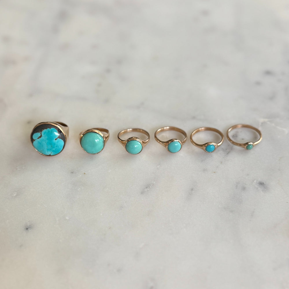 Handmade Bronze Turquoise Rings In Various Sizes on a Marble Surface | MIMOSA Handcrafted