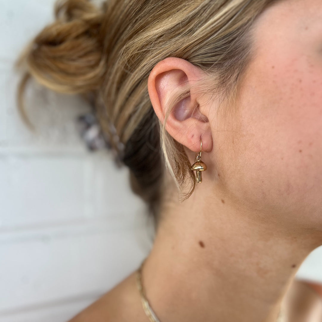 Woman Wears MIMOSA Handcrafted Mushroom Earrings in Bronze.