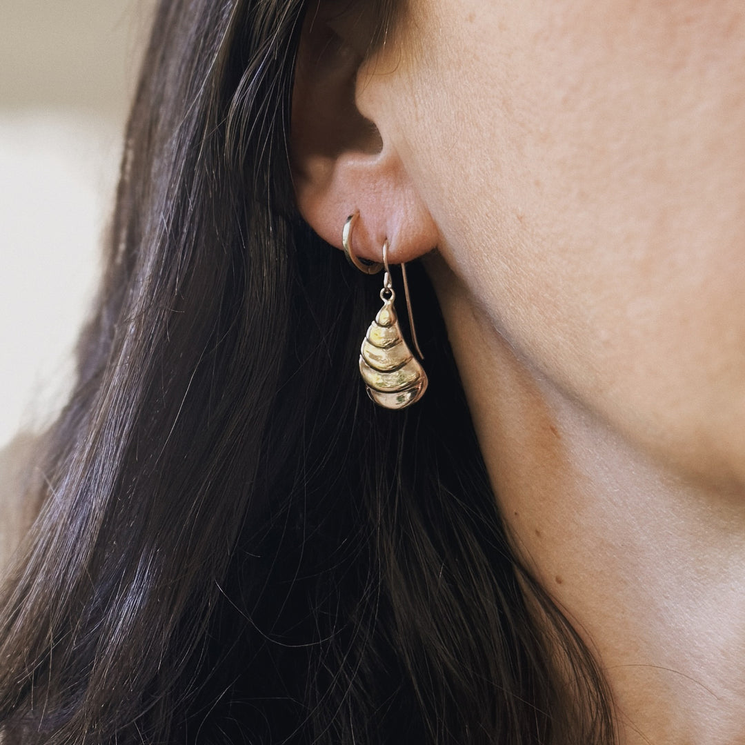 Person wears Bronze Oyster Shell Earrings from MIMOSA Handcrafted