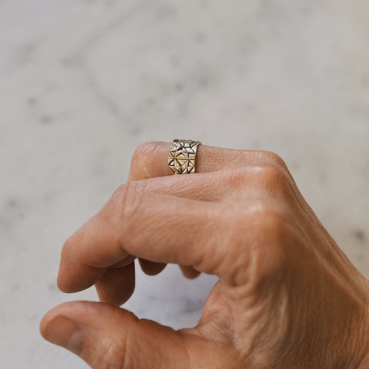 Person wears a handmade quilt square ring in bronze by MIMOSA Handcrafted.