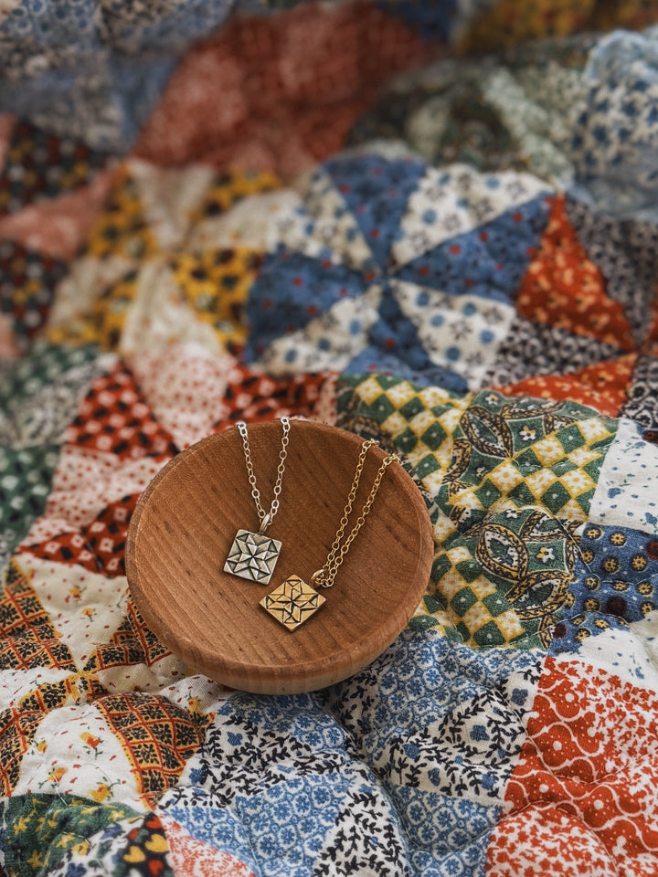 Handmade quilt square necklaces in silver and bronze