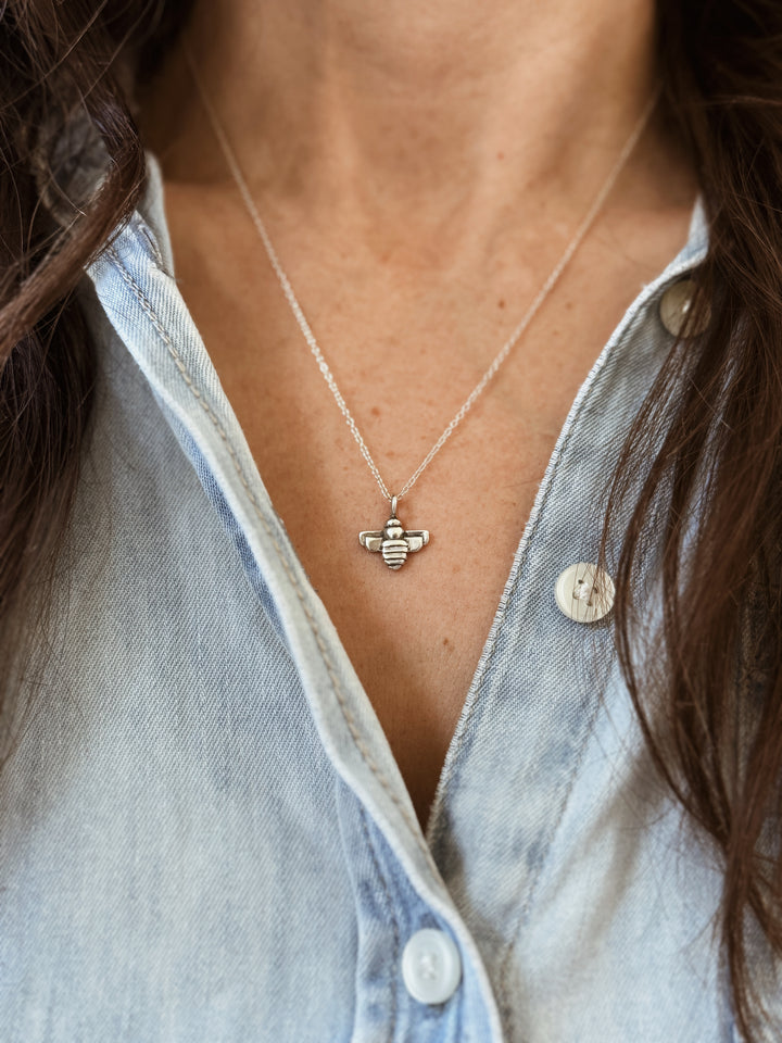 Woman Wears the MIMOSA Handcrafted Small Bee Pendant in Sterling Silver