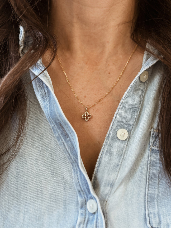 Woman Wears the MIMOSA Handcrafted Small Quatrefoil Pendant in Bronze