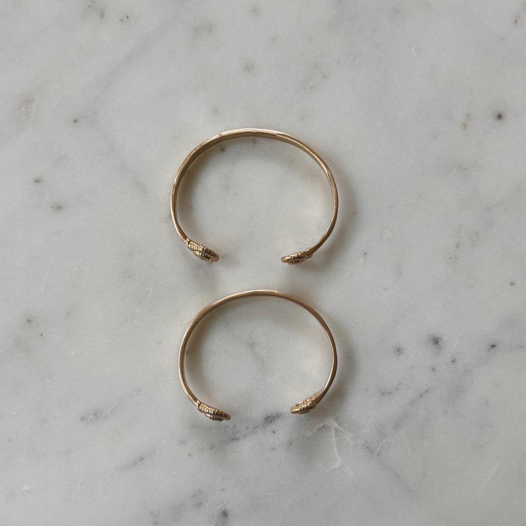 Small and Medium Size Bronze Bracelets on Marble Surface