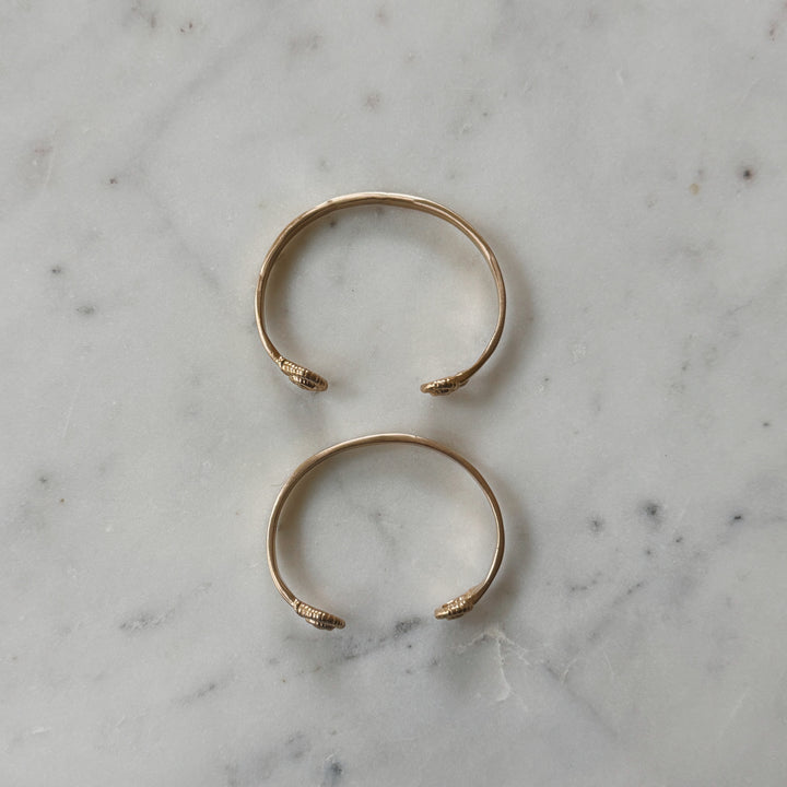 Small and Medium Size Bronze Bracelets on Marble Surface
